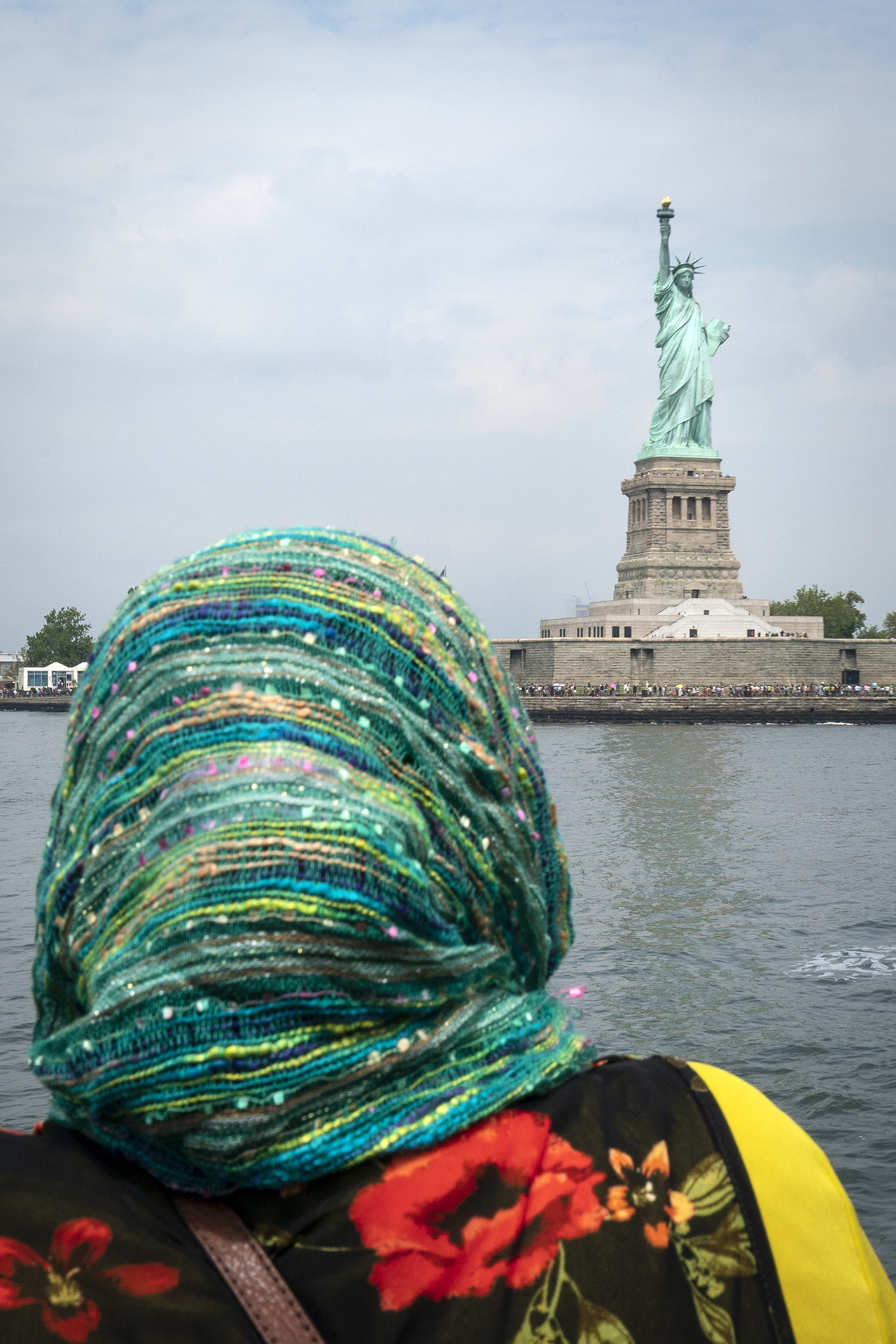 <p>A woman rides a ferry toward the Statue of Liberty on August 14, 2019, in New York City.</p>
