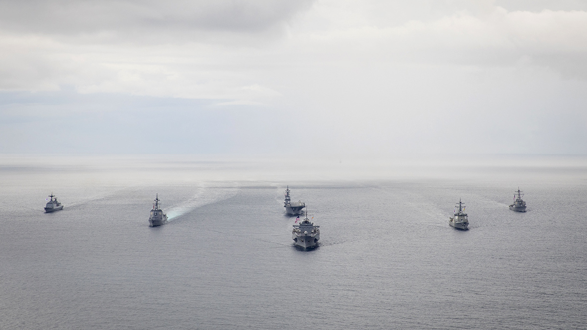 Several U.S. naval vessels cruising on open water.