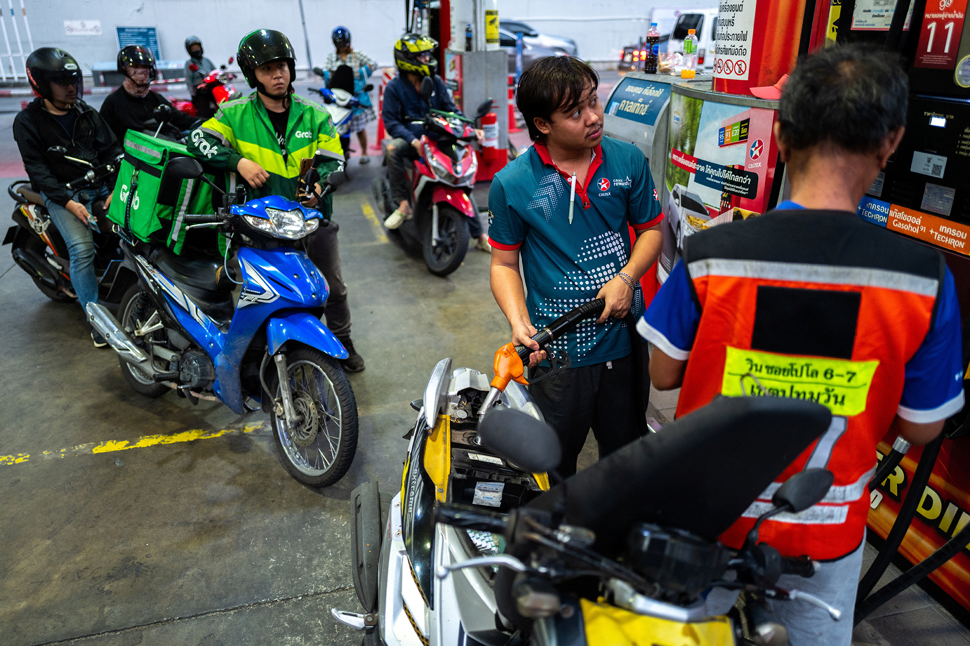 Riders with vehicles queue to fill up fuel at a gas station amid the U.S.-Israeli conflict with Iran, in Bangkok, Thailand, March 26, 2026.
